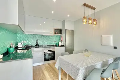 a kitchen with a table and chairs and a kitchen with green at A Casa Azul - Arco da Calheta in Arco da Calheta