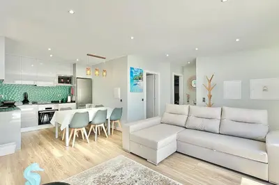 a living room with a white couch and a kitchen at A Casa Azul - Arco da Calheta in Arco da Calheta
