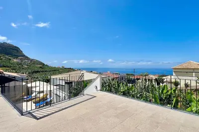 a balcony of a house with a view of the ocean at A Casa Azul - Arco da Calheta in Arco da Calheta