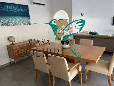 a dining room with a wooden table and chairs at Casa Colibri I in Luz