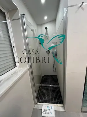 a bathroom with a shower with a bird on the wall at Casa Colibri I in Luz