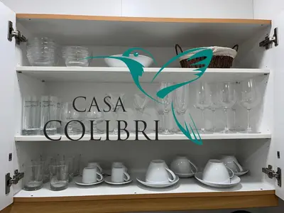 a cupboard with glasses and a sign that reads casa colibri at Casa Colibri I in Luz