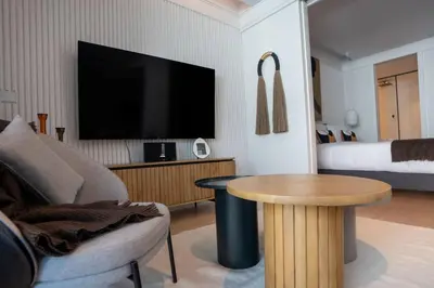 a living room with a tv and a table and a bed at Empire Luxury Suite - Savoy Insular in Funchal
