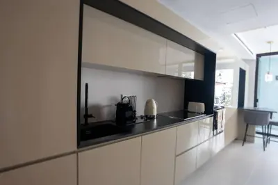 a kitchen with white cabinets and a black counter top at Empire Luxury Suite - Savoy Insular in Funchal