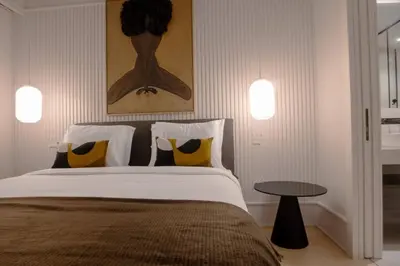 a bedroom with a bed with two pillows and a table at Empire Luxury Suite - Savoy Insular in Funchal