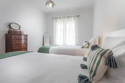 a bedroom with two beds and a dresser and a window at Jango Paradise in Funchal