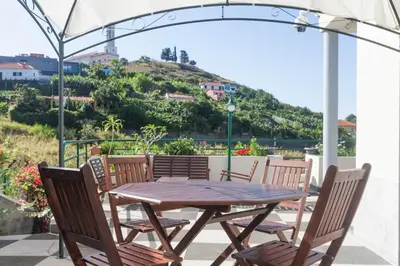 a wooden table and chairs with a view of a hill at Jango Paradise in Funchal