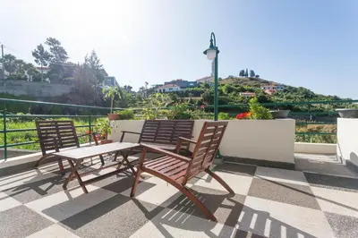 two wooden chairs and a table on a roof at Jango Paradise in Funchal