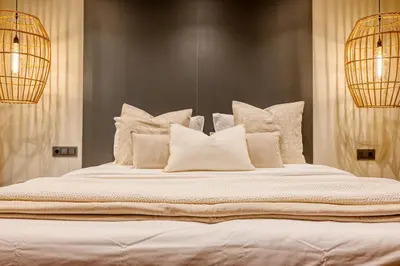a large white bed with white pillows and two lights at Machico Fachos View, a Home in Madeira in Machico