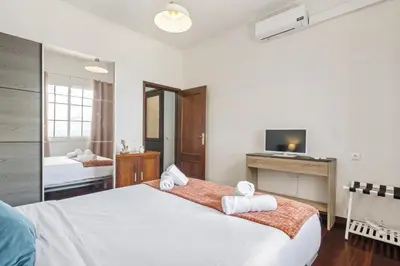 a bedroom with a large white bed and a television at Funchal Ocean Terrace APT in Funchal