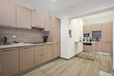 a kitchen with brown cabinets and a wooden floor at Funchal Ocean Terrace APT in Funchal