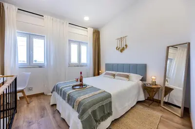 a bedroom with a large bed and a mirror at Casa Clara in Vila do Bispo