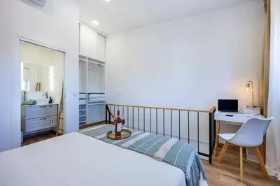 a bedroom with a bed and a desk and a chair at Casa Clara in Vila do Bispo
