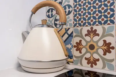 a tea kettle on a shelf in a kitchen with tiles at Casa Clara in Vila do Bispo