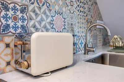a white appliance sitting on a kitchen counter next to a sink at Casa Clara in Vila do Bispo
