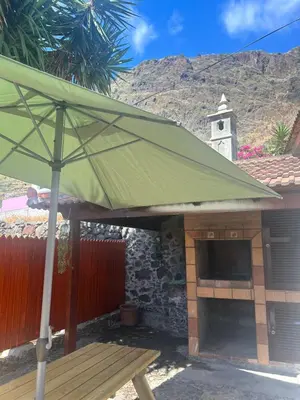 a green umbrella sitting in front of a building at Palheiro Mar by Olá Madeira in Paul do Mar