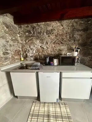 a kitchen with a white counter and a sink at Palheiro Mar by Olá Madeira in Paul do Mar
