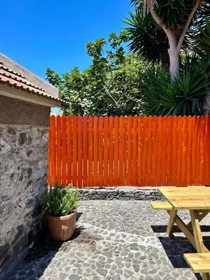 a wooden fence with a wooden picnic table and a bench at Palheiro Mar by Olá Madeira in Paul do Mar