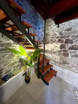 a staircase in a room with a stone wall at Palheiro Jardim by Olá Madeira in Paul do Mar