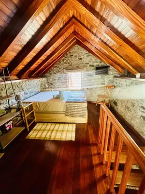 a bedroom with a bed in a stone building at Palheiro Jardim by Olá Madeira in Paul do Mar
