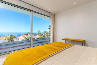 a bedroom with a large window and a bed at El Dourado House in Caniço