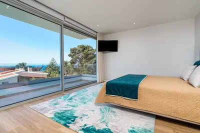 a bedroom with a large bed and a large window at El Dourado House in Caniço