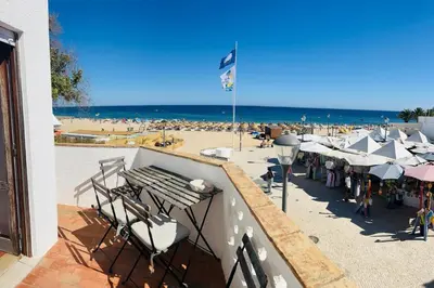 a view of a beach with chairs and umbrellas at STUNNING BEACH PENTHOUSE Best Views In Luz in Luz