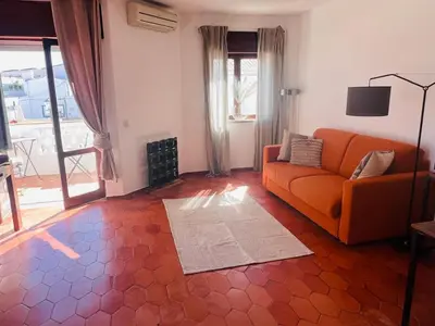 a living room with an orange couch and a fireplace at STUNNING BEACH PENTHOUSE Best Views In Luz in Luz