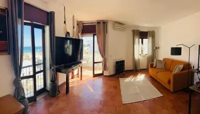 a living room with a couch and a television at STUNNING BEACH PENTHOUSE Best Views In Luz in Luz