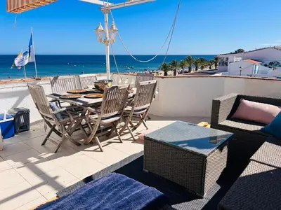 a patio with a table and chairs and the beach at STUNNING BEACH PENTHOUSE Best Views In Luz in Luz