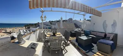 a balcony with a table and chairs and the beach at STUNNING BEACH PENTHOUSE Best Views In Luz in Luz