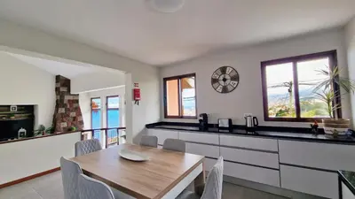 a kitchen and dining room with a wooden table at Casa Clementine by LovelyStay in Funchal