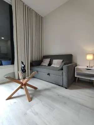 a living room with a couch and a glass table at Serenity Studio in Caniço