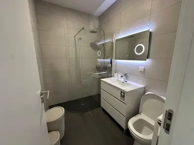 a bathroom with a sink and a toilet and a mirror at Serenity Studio in Caniço