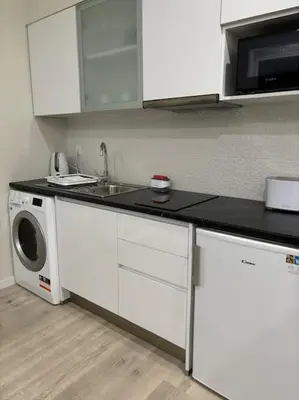 a kitchen with a sink and a washing machine at Serenity Studio in Caniço
