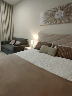 a bedroom with a large bed and a couch at Serenity Studio in Caniço