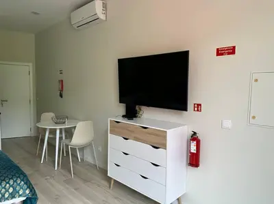 a living room with a television on a white dresser at Serenity Studio in Caniço
