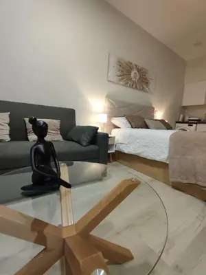 a living room with a couch and a glass table at Serenity Studio in Caniço