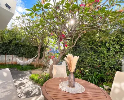 a wooden table with a tree in a yard at The Luzia House - sunny 4BR Villa with gardens, terraces, AC, on-site parking in Funchal