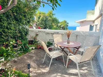 a patio with a table and chairs on a patio at The Luzia House - sunny 4BR Villa with gardens, terraces, AC, on-site parking in Funchal