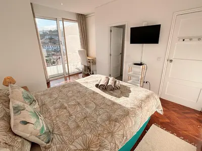 a bedroom with a bed with two shoes on it at The Luzia House - sunny 4BR Villa with gardens, terraces, AC, on-site parking in Funchal