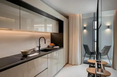 a kitchen with a sink and two chairs at Savoy Insular VI by An Island Apart in Funchal