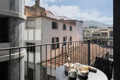 a table on a balcony with a view of a city at Savoy Insular VI by An Island Apart in Funchal