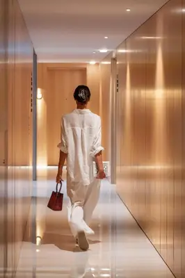a woman walking down a hallway in a elevator at Savoy Insular VI by An Island Apart in Funchal