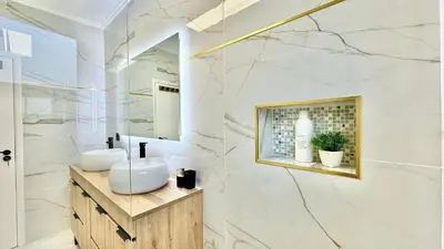 a bathroom with two sinks and a mirror at The North Paradise - Porto Moniz in Porto Moniz