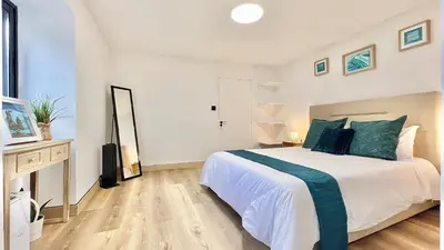 a bedroom with a large white bed with blue pillows at The North Paradise - Porto Moniz in Porto Moniz