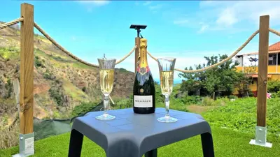 a bottle of wine and two glasses on a table at The North Paradise - Porto Moniz in Porto Moniz