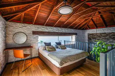 a bedroom with a bed and a wooden ceiling at Meerblick - Exklusives Loft mit Terrassen & Hot-Tub in Fajã da Ovelha