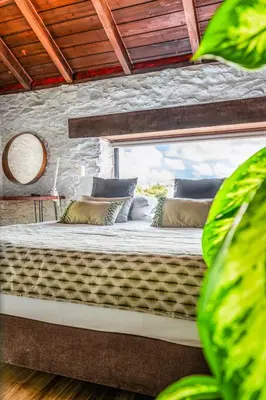 a bedroom with a large bed with a large window at Meerblick - Exklusives Loft mit Terrassen & Hot-Tub in Fajã da Ovelha
