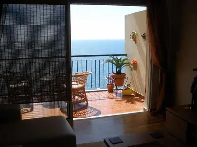 a room with a view of the ocean from a balcony at Magos Sunrise - Apt with sea view in Caniço